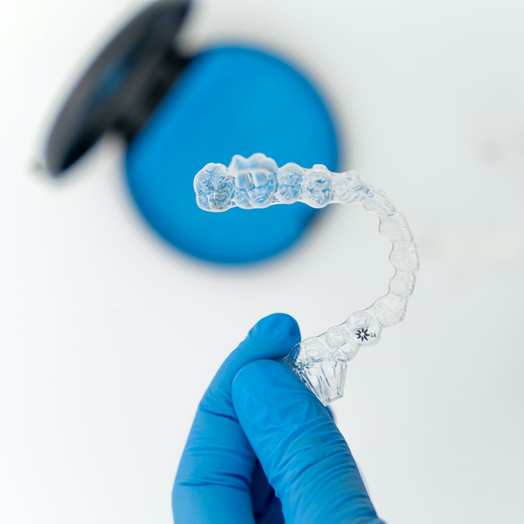 brisbane orthodontist holding an invisalign clear aligner